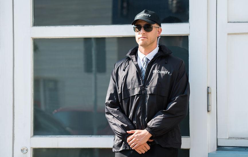 Young Male Security Guard Standing At The Entrance